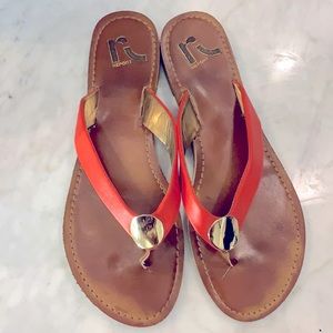 Report orange leather flip flops.